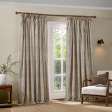 Hebden Fully Lined Cotton Pencil Pleat Curtains in Chocolate, cream and brown striped cotton panels hung from a wooden pole in a living room beside a window.
