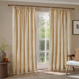 Hebden fully lined pencil pleat curtains in honey-yellow and cream cotton stripe, hung on a wooden pole beside a window in a living room.