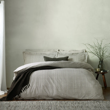 Hebden Cotton Melange Duvet Cover Set in Black on a bed with matching pillowcases, a dark textured throw, and a plain square cushion in a bedroom setting.