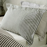Hebden Cotton Melange Duvet Cover Set in Black, shown on a bed with striped pillow shams and matching sheets in a bedroom setting.