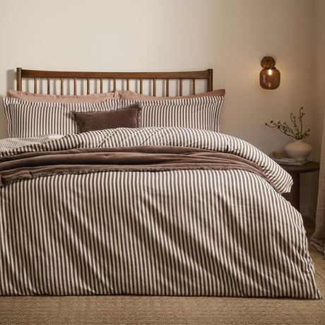 Hebden Cotton Melange Duvet Cover Set in espresso brown stripe on cream, styled on a bed with matching pillowcases and a velvet cushion in a bedroom setting.