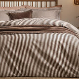 Hebden Cotton Melange Duvet Cover Set in espresso brown stripe on cream, shown on a bed with matching pillowcases and brown velvet cushions and throw.