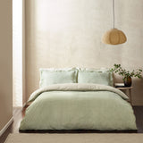 Hebden Cotton Striped Duvet Cover Set in Forest green and cream, styled on a bed with matching pillowcases in a neutral bedroom with a woven pendant light.