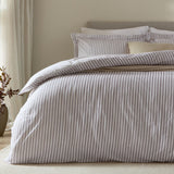 Hebden Cotton Melange Duvet Cover Set in mauve, styled on a bed with fine mauve-and-white striped cover and matching pillowcases against a neutral bedroom backdrop.