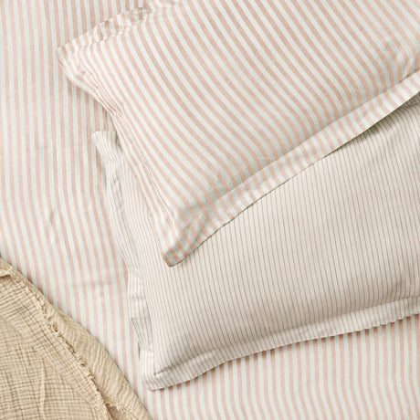 Hebden Melange Cotton Pillowcase Pair in Blush, cotton pillowcases with Oxford border in a blush-pink striped print on cream, shown with striped duvet bedding.