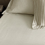 Hebden Striped Cotton Fitted Sheet in mole, made up on a bed with matching pillowcase, showing fine taupe-grey pinstripes on a cream cotton ground.