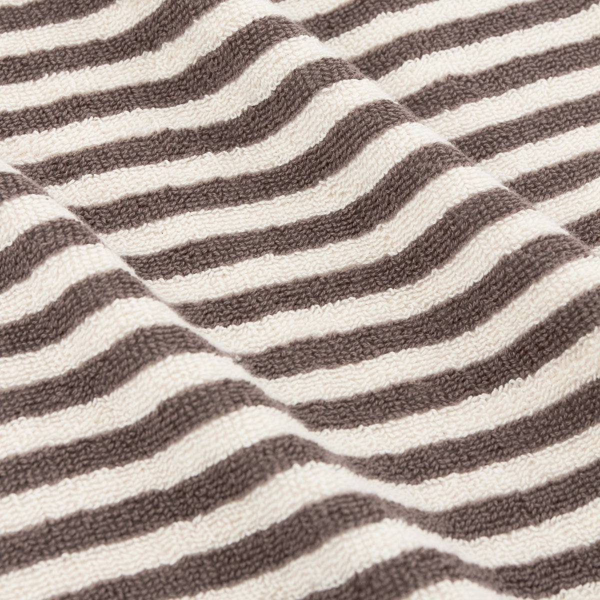 Close-up of Hebden Striped Cotton Towel in chocolate brown, showing woven terry towelling with vertical stripes against a soft cream ground.