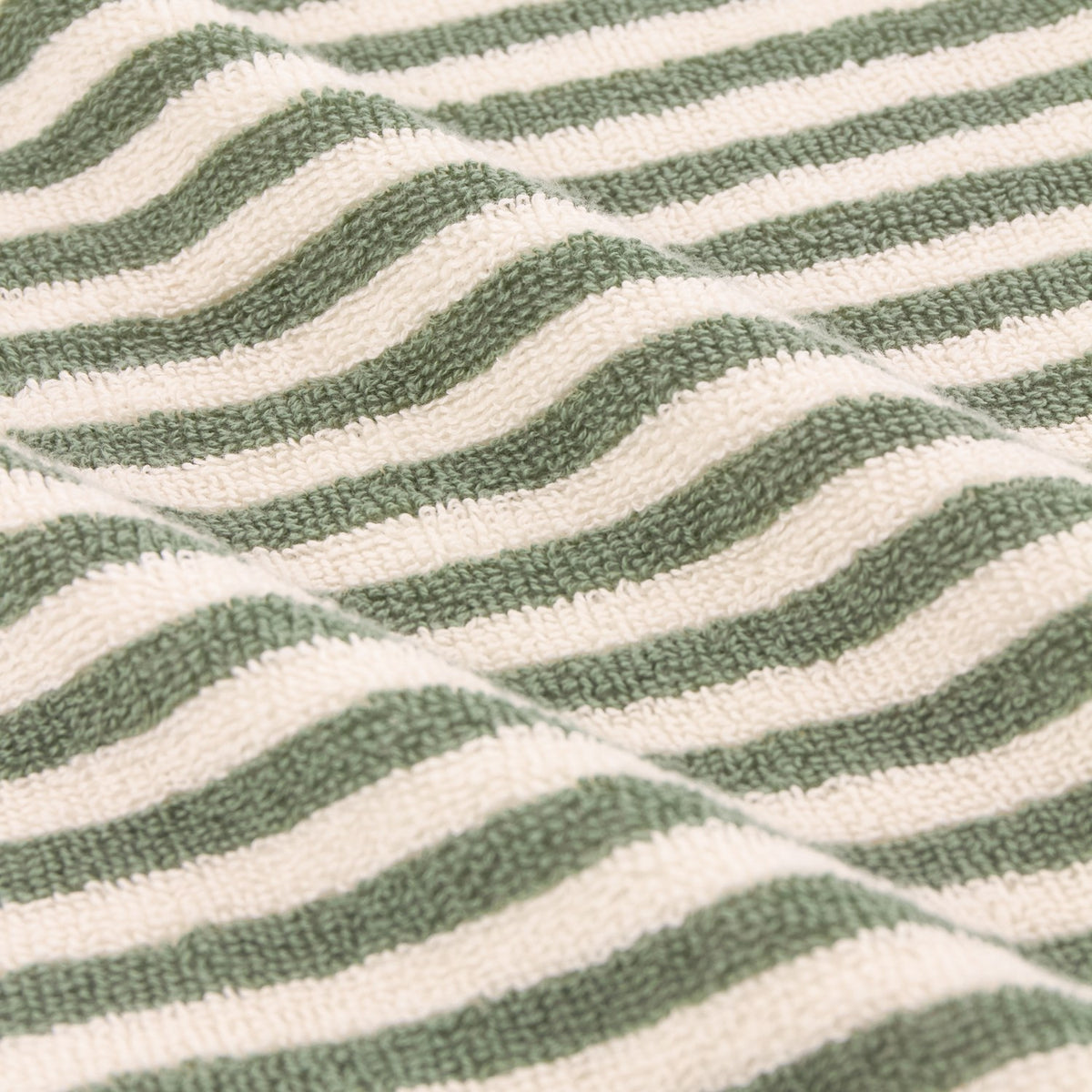 Close-up of the Hebden Striped Cotton Towels in Forest, showing woven cotton terry fabric with even green and cream vertical stripes.