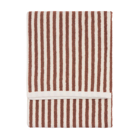 Folded cotton towel with vertical pecan brown and cream stripes and a looped terry pile, shown on a plain white background.