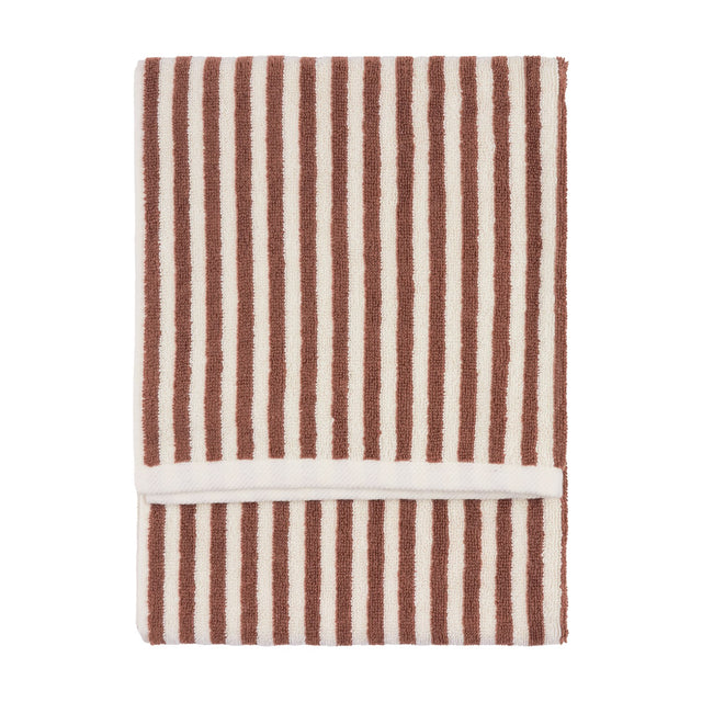 Folded cotton towel with vertical pecan brown and cream stripes and a looped terry pile, shown on a plain white background.