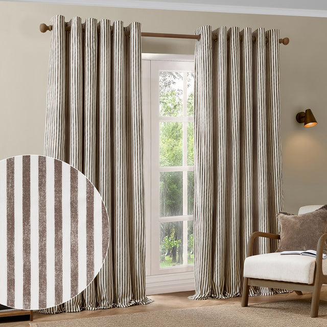 Hebden Cotton Printed Eyelet Curtains in Chocolate, striped brown and cream cotton panels with eyelet header, shown framing a window in a living room with an armchair.