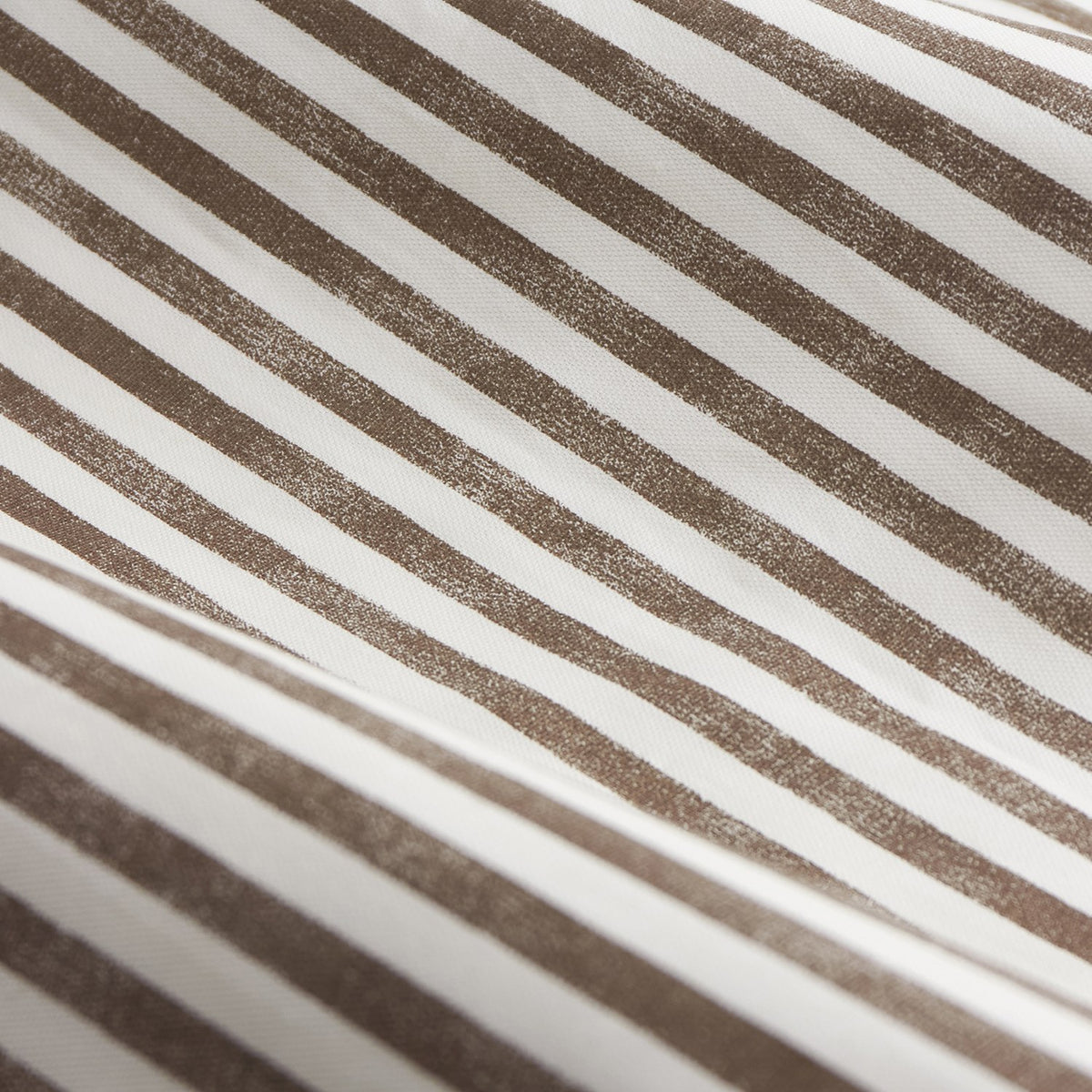 Close-up of the Hebden Cotton Printed Eyelet Curtains fabric, showing diagonal chocolate-brown stripes printed on an off-white cotton ground with a woven-look texture.