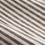 Close-up of the Hebden Cotton Printed Eyelet Curtains fabric, showing diagonal chocolate-brown stripes printed on an off-white cotton ground with a woven-look texture.