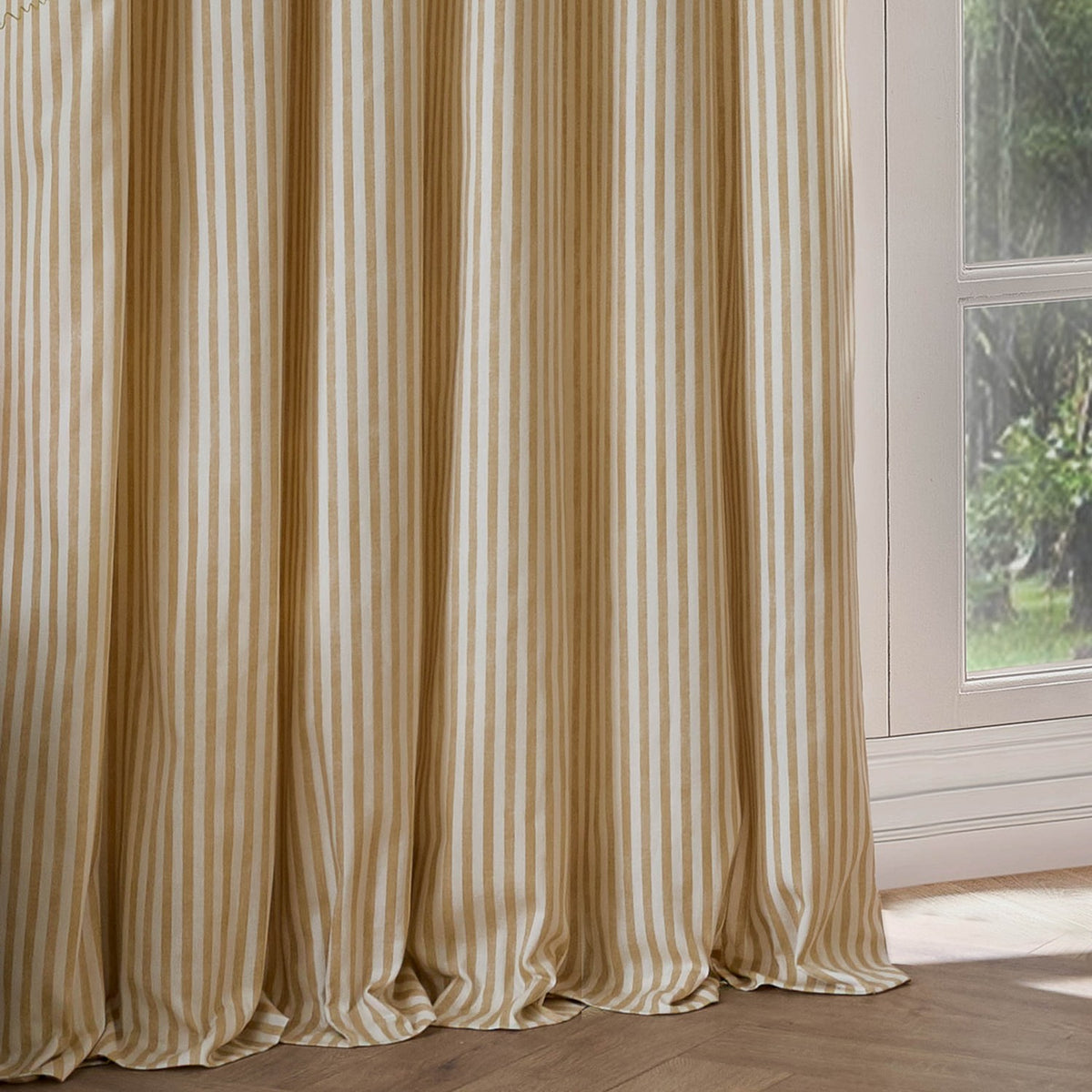 Hebden Cotton Printed Eyelet Curtains in Honey Yellow, showing vertical woven-look stripes in soft pleats beside a window in a living room setting.