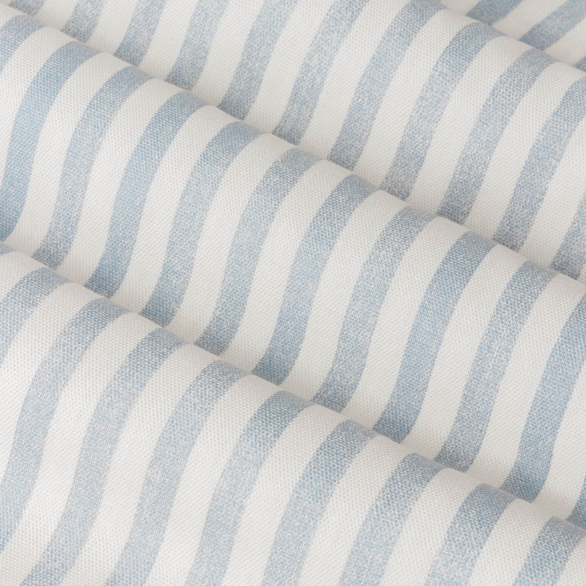Close-up of Hebden Cotton Printed Eyelet Curtains in Mineral Blue, showing soft blue and cream vertical stripes on textured cotton fabric with folded drapery.