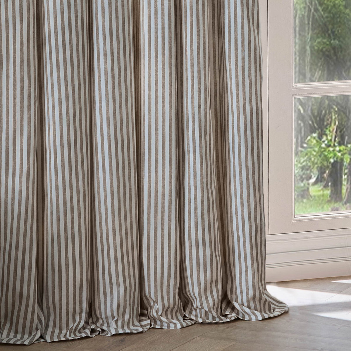 Hebden Cotton Printed Eyelet Curtains in Mole, showing mole brown and off-white striped cotton panels with eyelet header, hanging beside a window in a living room.
