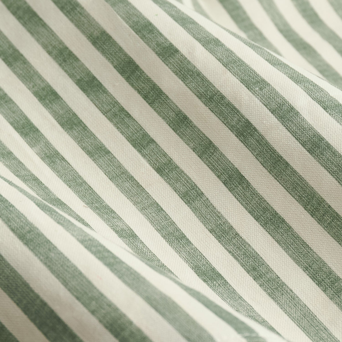 Close-up of the Hebden Pencil Pleat Curtains fabric, showing a forest-green diagonal stripe pattern on off-white 100% cotton with a woven texture.