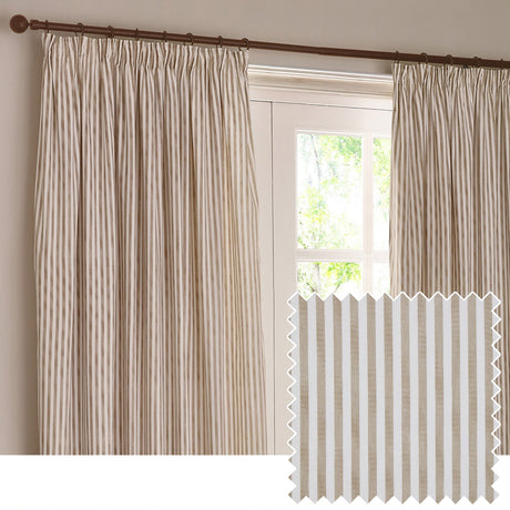 Hebden striped cotton pencil pleat curtains in natural tan and off-white, hung on a dark pole beside a window, with a fabric swatch inset showing the vertical stripe weave.