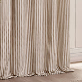 Hebden pencil pleat curtains in natural tan and off-white vertical stripe, 100% cotton fabric falling in gathered folds beside a light wall and wooden floor.