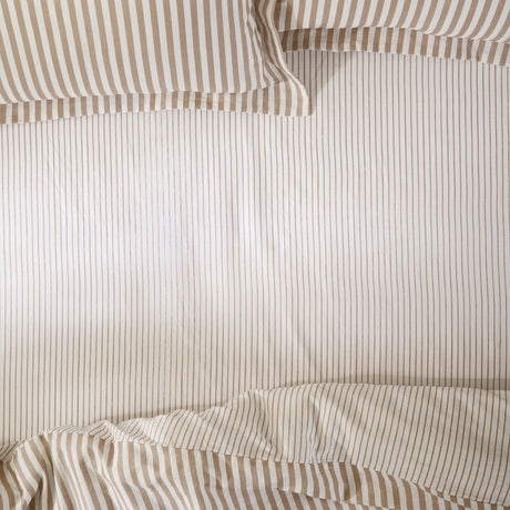 Hebden Striped Cotton Fitted Sheet in Caramel, showing a fine caramel pinstripe on a soft white cotton ground across a fitted sheet and matching pillowcases.
