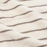 Close-up of the Hebden Striped Cotton Towel in Mole, showing textured cream terry fabric with slim, evenly spaced greyish-brown stripes running lengthwise.