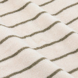 Close-up of the Hebden Striped Cotton Towel in olive, showing narrow green stripes on a cream terry pile fabric folded in soft waves.