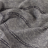 Close-up of the Hedon Striped Polyester Throw in navy, showing a woven navy and cream marl texture with a subtle linear stripe detail, draped in soft folds.
