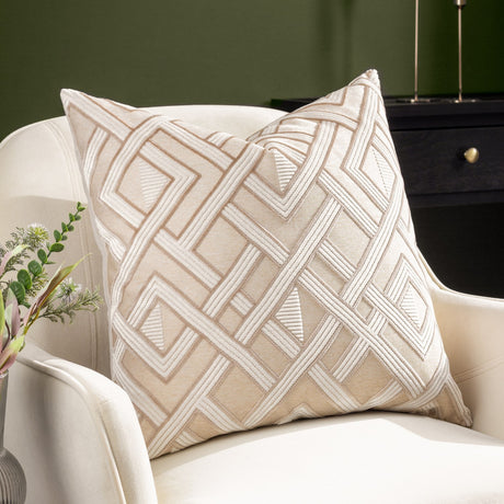 Henley Jacquard Velvet Cushion in warm taupe with raised off-white geometric lattice pattern, styled on a cream armchair in a living room setting.