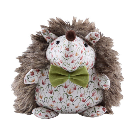 Henrietta Polyester Door Stop shaped like a hedgehog with shaggy brown faux fur back, cream floral fabric face and belly, a pom-pom nose, and an olive-green bow, on a plain white background.