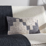 Himal Abstract Cotton Cushion in Dusk, an oblong lumbar cushion with a stepped grey and cream pattern combining flat weave and raised loop textures, shown on a boucle sofa.
