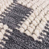 Close-up of the Himal Abstract Cotton Cushion in Dusk, showing raised cream knotted loops against flat woven charcoal grey cotton in a stepped, interlocking pattern.