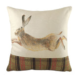 Hunter Animal Linen Cushion in Multicolour, square with a hand-painted leaping hare in brown and tan tones on natural fabric, above a green, black and red tartan panel, shown on a white background.