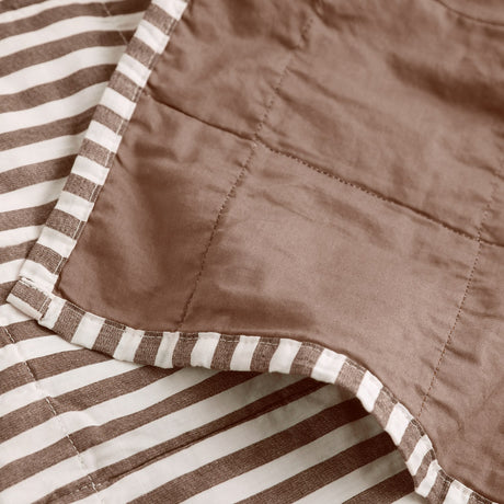 Close-up of the Hebden Percale Cotton Bedspread in Cocoa Brown, showing the quilted stitching where the striped cotton face meets the plain tonal brown reverse.