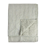 Folded Hebden cotton bedspread in green and white stripe, showing the plain sage green quilted reverse, on a plain white background.