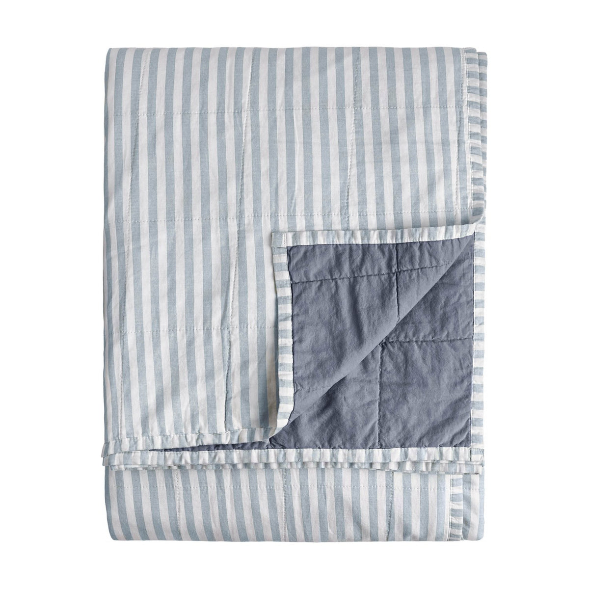 Hebden Percale Cotton Bedspread, folded to show reversible sides, one face with pale mineral blue and white stripes, the other in plain denim-blue quilted cotton, on a white background.