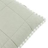 Close-up of the Hebden Percale Cotton Cushion in Eucalyptus/Bay Green, showing quilted sage cotton front and striped green-and-white edge trim on a white background.