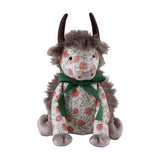 Hugo Polyester Door Stop shaped as a highland cow, with shaggy mane, dark curved horns, grey muzzle and paws, a coral floral print body tied with a green ribbon bow, on a plain white background.