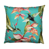 Square polyester outdoor cushion in blue-green with two hummingbirds and trailing pink and coral tropical flowers, shown on a plain white background.