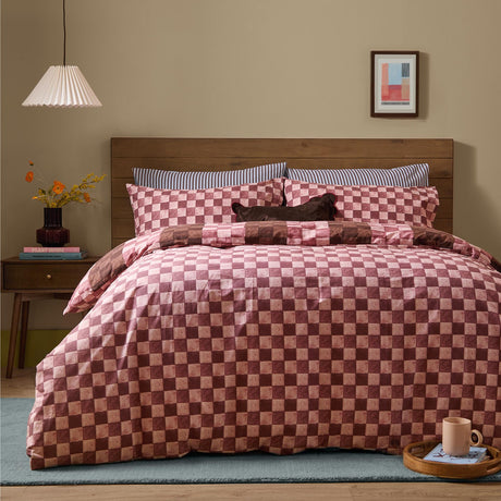 Huxley Reversible Check Duvet Cover Set in chocolate and blush on a bed with matching pillowcases, wooden headboard, and neutral bedroom setting.