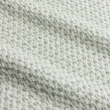 Close-up of the Hebden Plain Cotton Towels in Bay Green, showing a textured waffle-weave cotton surface with pale, near-white flecks.