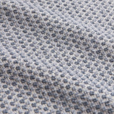 Close-up of Hebden Plain Cotton Towel in denim blue, showing the woven waffle texture with raised cotton pockets in a soft blue and pale grid pattern.