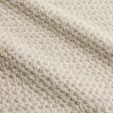Close-up of Hebden Plain Cotton Towels in stone, showing the textured waffle weave and honeycomb surface of the cream cotton fabric.