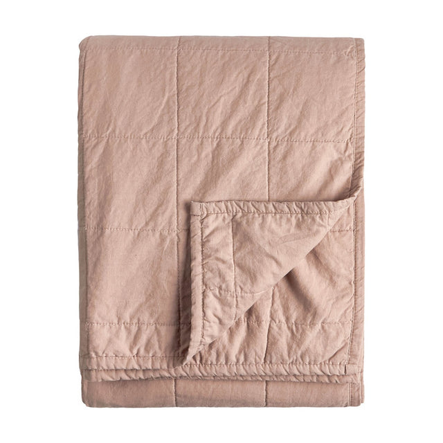 Folded Hebden quilted cotton percale bedspread in warm pink (Cotta), showing a grid-stitched face and reverse corner fold, on a plain white background.