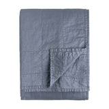 Hebden Percale Cotton Bedspread in denim blue, folded to show quilted grid stitching and matching reverse side, on a plain white background.