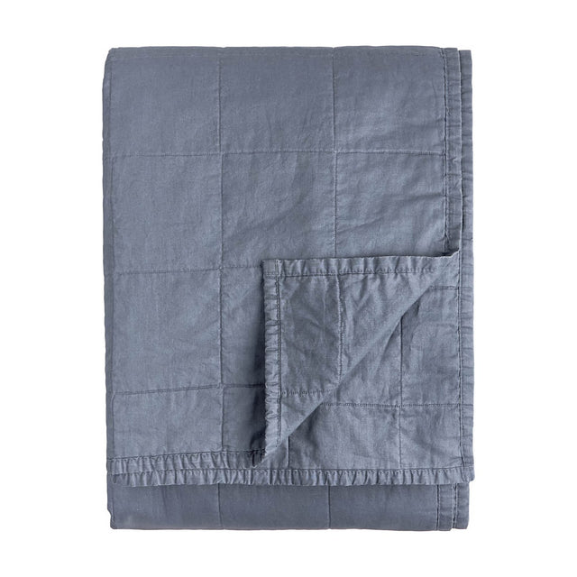 Hebden Percale Cotton Bedspread in denim blue, folded to show quilted grid stitching and matching reverse side, on a plain white background.