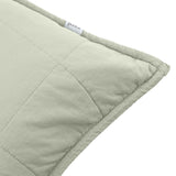 Close-up of the Hebden Percale Cotton Cushion in Bay Green, showing quilted grid stitching on soft sage cotton with a fabric brand label at the seam.