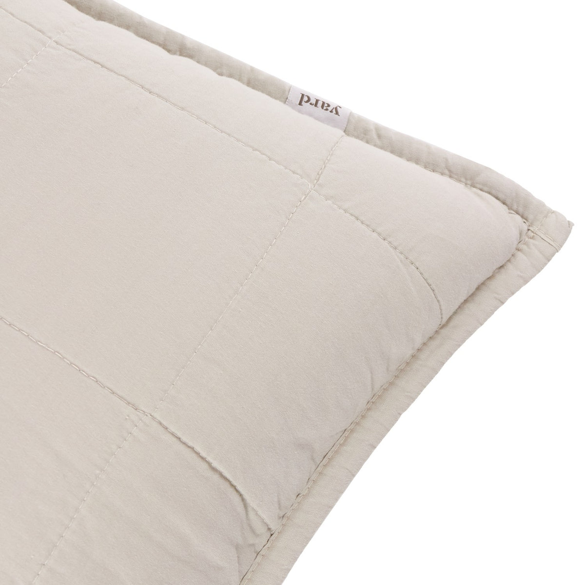 Close-up of the Hebden Percale Cotton Cushion in stone, showing quilted grid stitching, cotton fabric texture, and a corner label, on a white background.