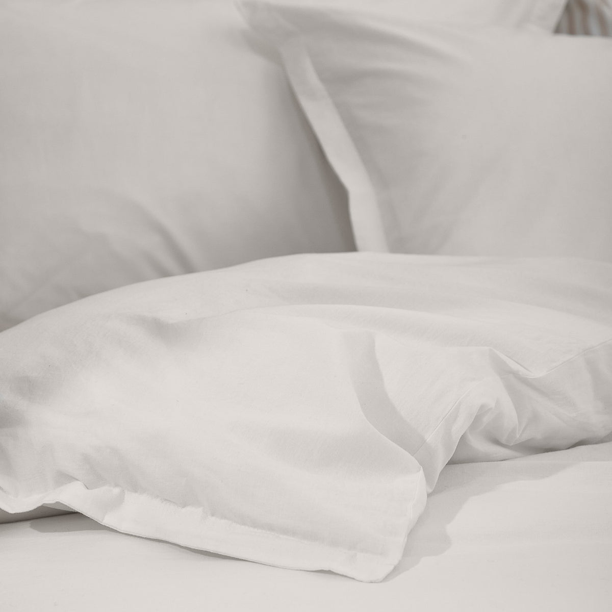 Hebden Cotton Plain Duvet Cover Set in chalk white, showing garment-washed cotton with a soft, slightly crumpled texture on pillows and bedding.