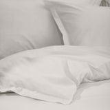 Hebden Cotton Plain Duvet Cover Set in chalk white, showing garment-washed cotton with a soft, slightly crumpled texture on pillows and bedding.