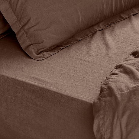 Close-up of the Hebden Percale Cotton Fitted Sheet in cocoa brown, showing the deep corner fit over a mattress with a matching crinkled pillowcase.
